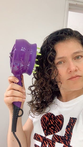 reviewer using the diffuser on their curly hair