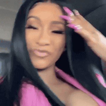 GIF of Cardi B stroking her hair with long, pink nails