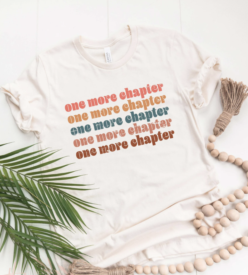 beige tshirt that reads one more chapter in many colors