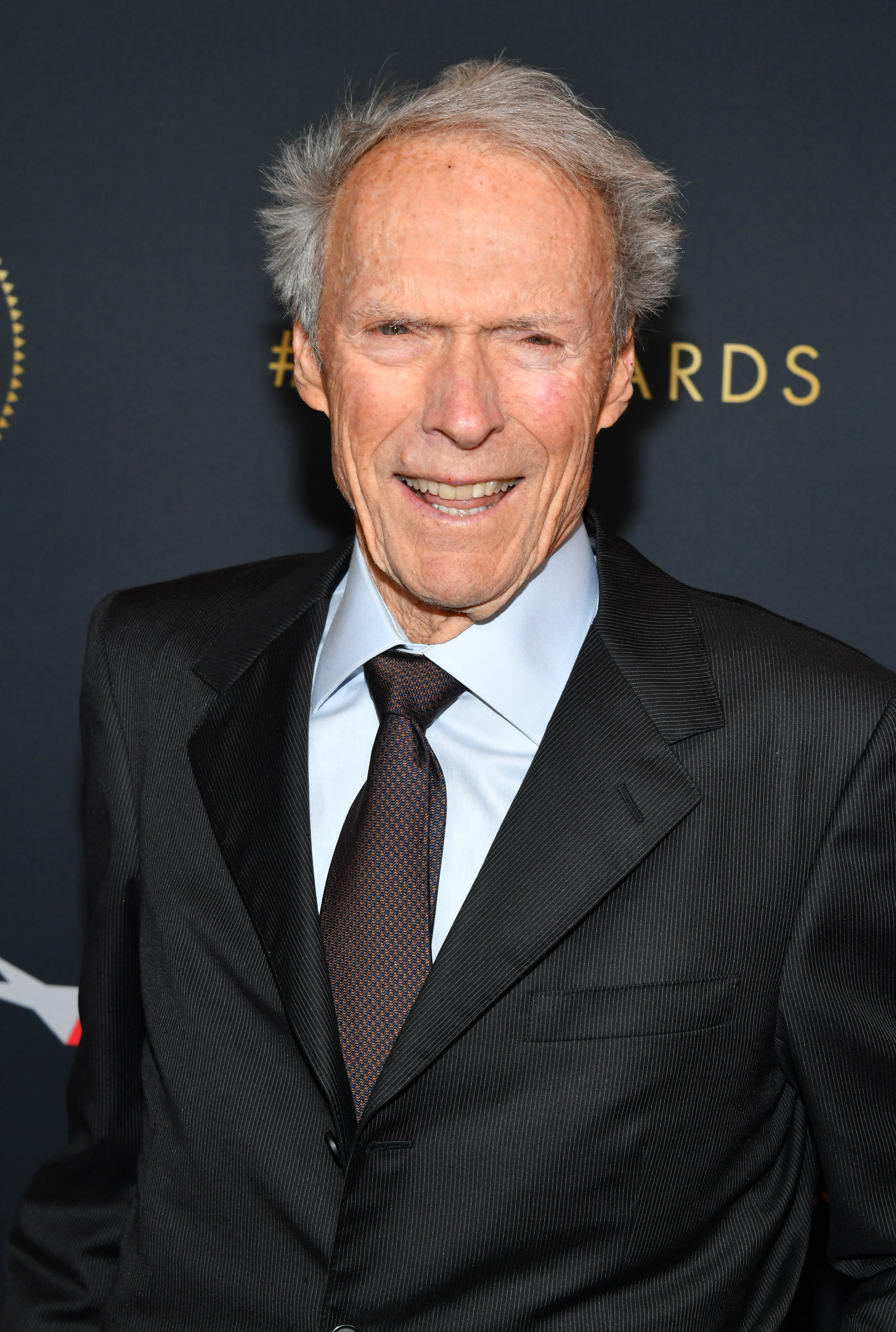 Clint Eastwood smiling in a suit