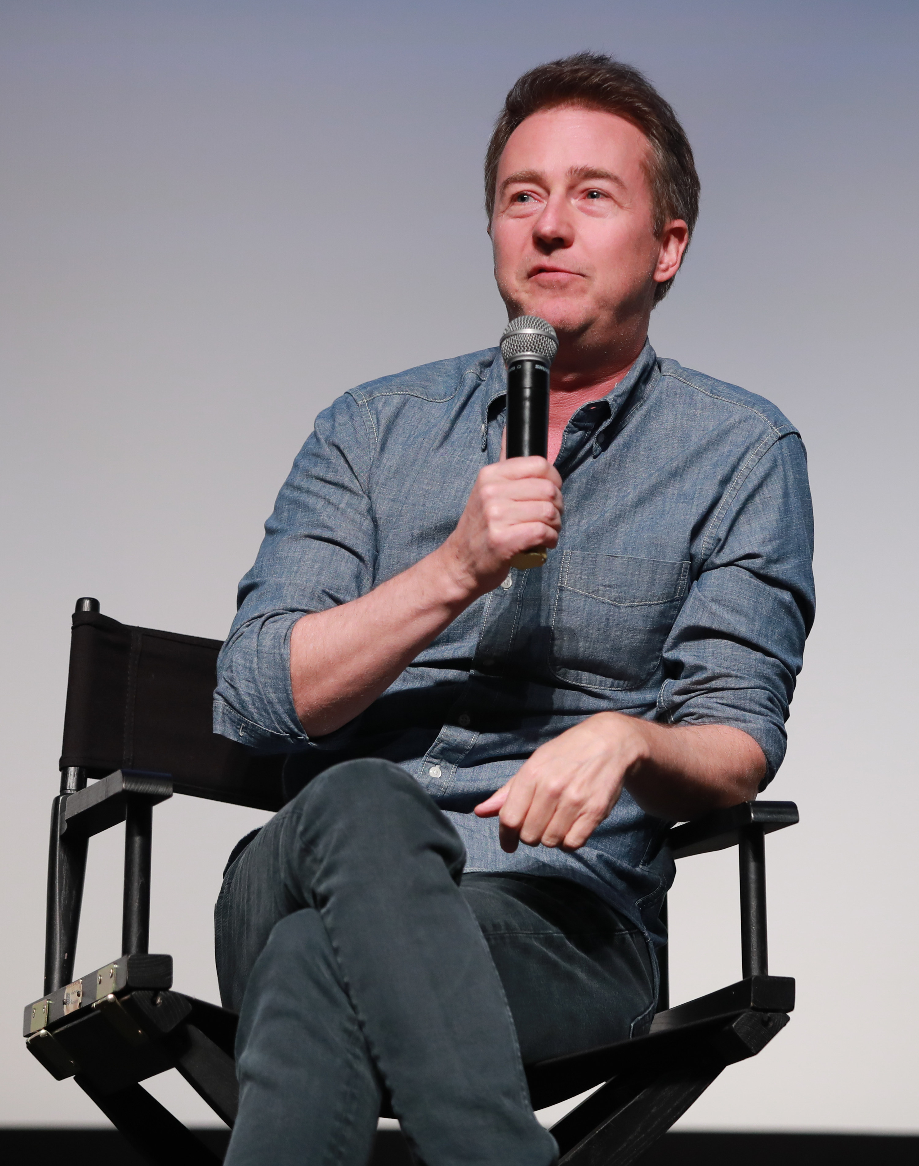 Edward Norton speaking into a microphone