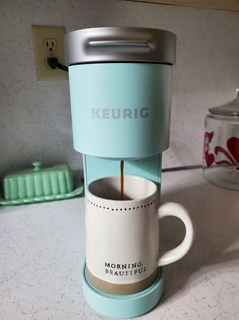 A reviewer shows the coffee maker in light blue