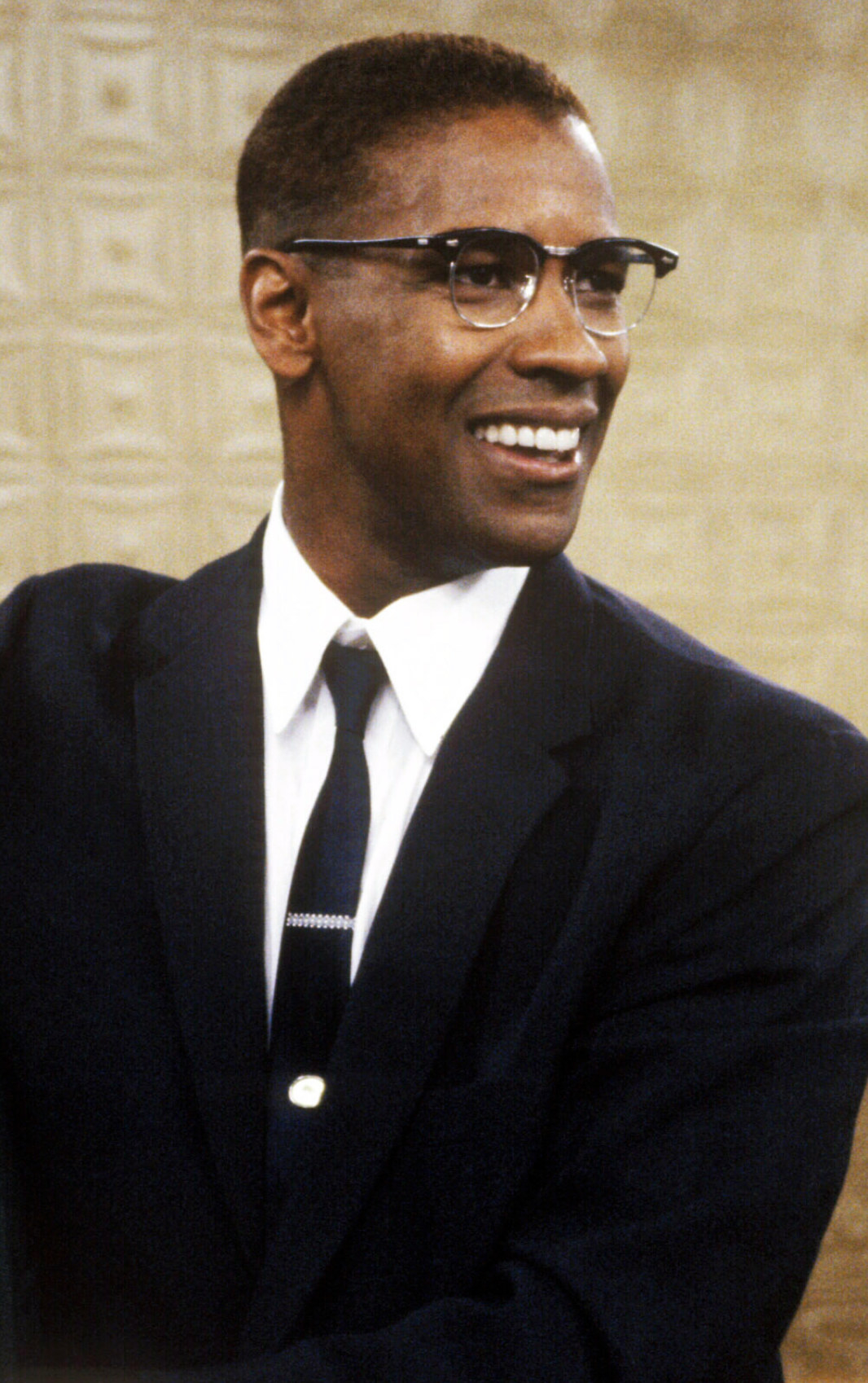 Washington wearing suit, tie, and Malcolm X glasses (black, round rim)