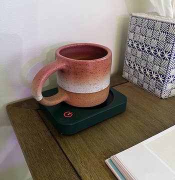 a reviewer's mug on a black mug warmer