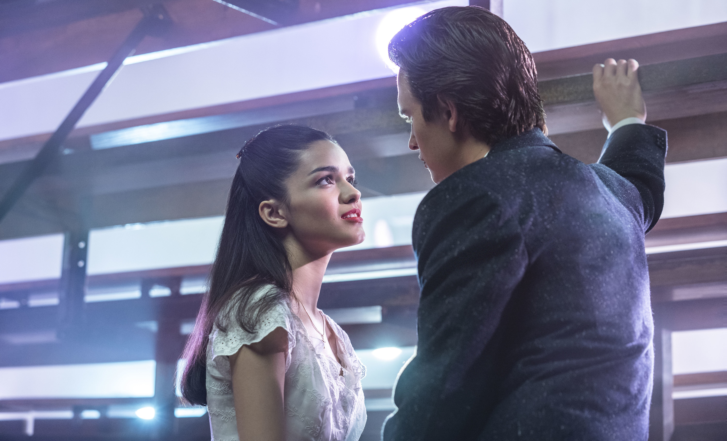 Maria and Tony stare lovingly at each other behind bleachers at the dance