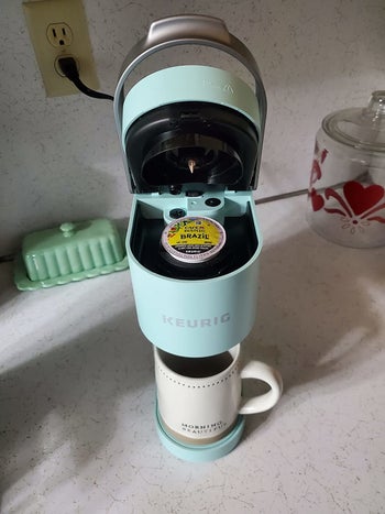 the same reviewer shows the open Keurig with a coffee pod inside