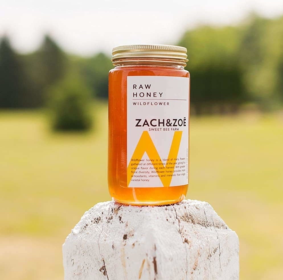 A jar of the wildflower honey resting on a post