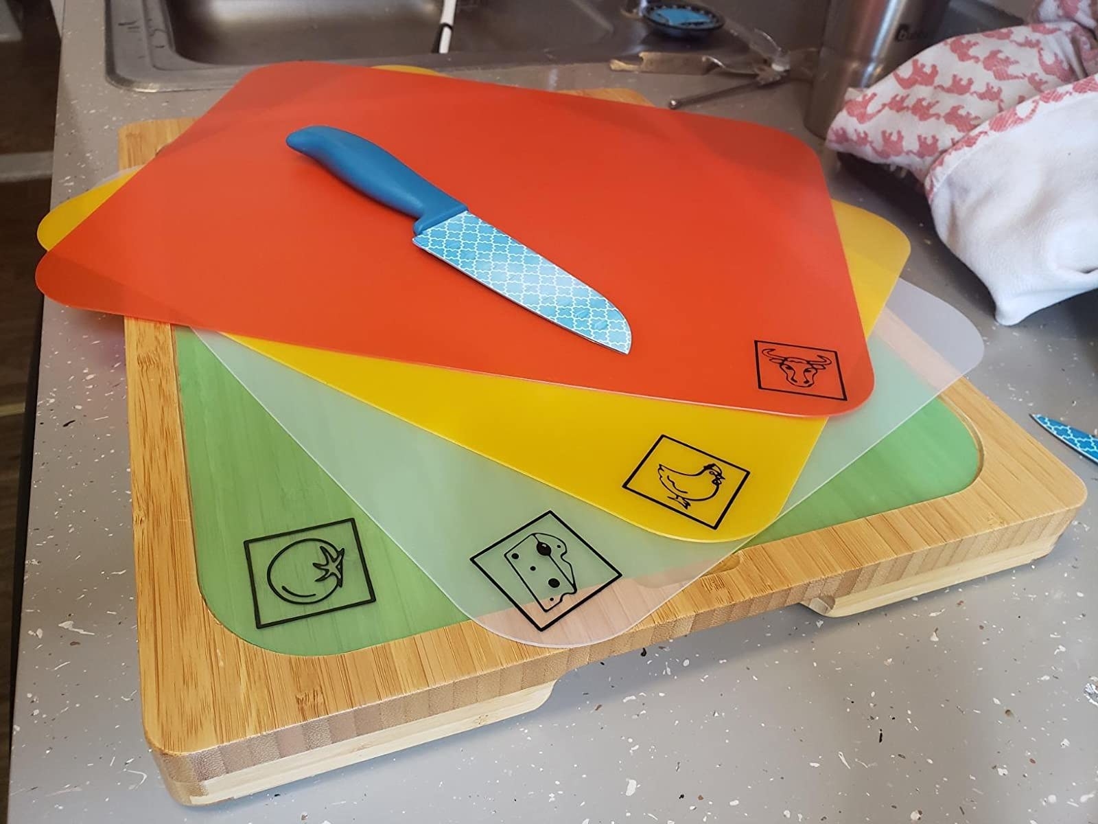 a reviewer shows the cutting board with  the beef, chicken, cheese, and fruit sheets.