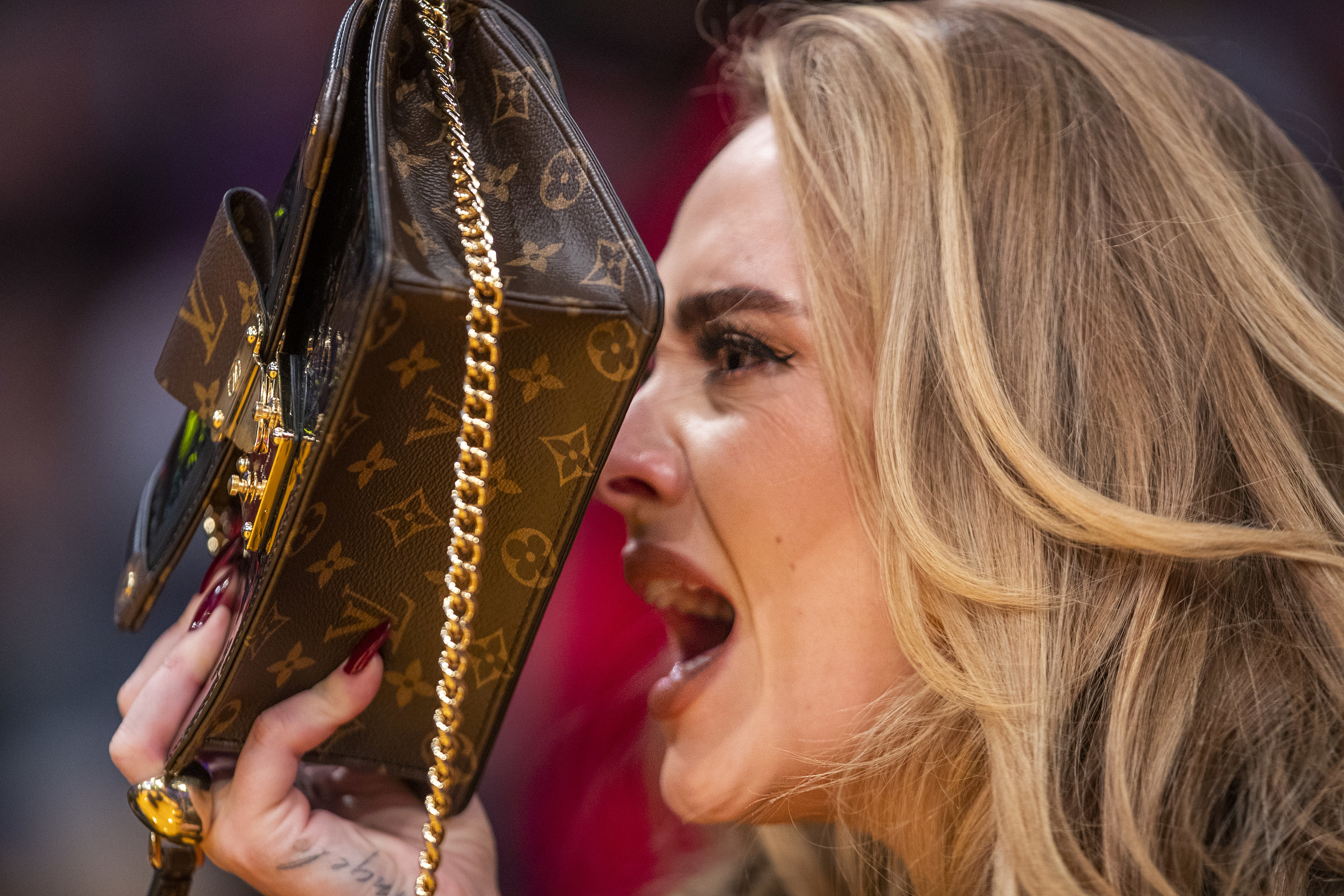 Adele makes a face while hiding behind her purse