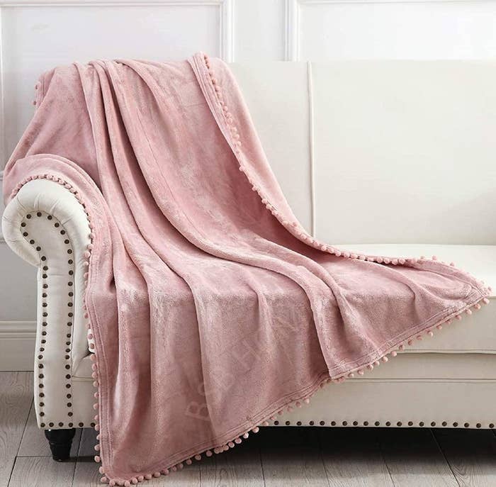 A pink throw blanket on a sofa