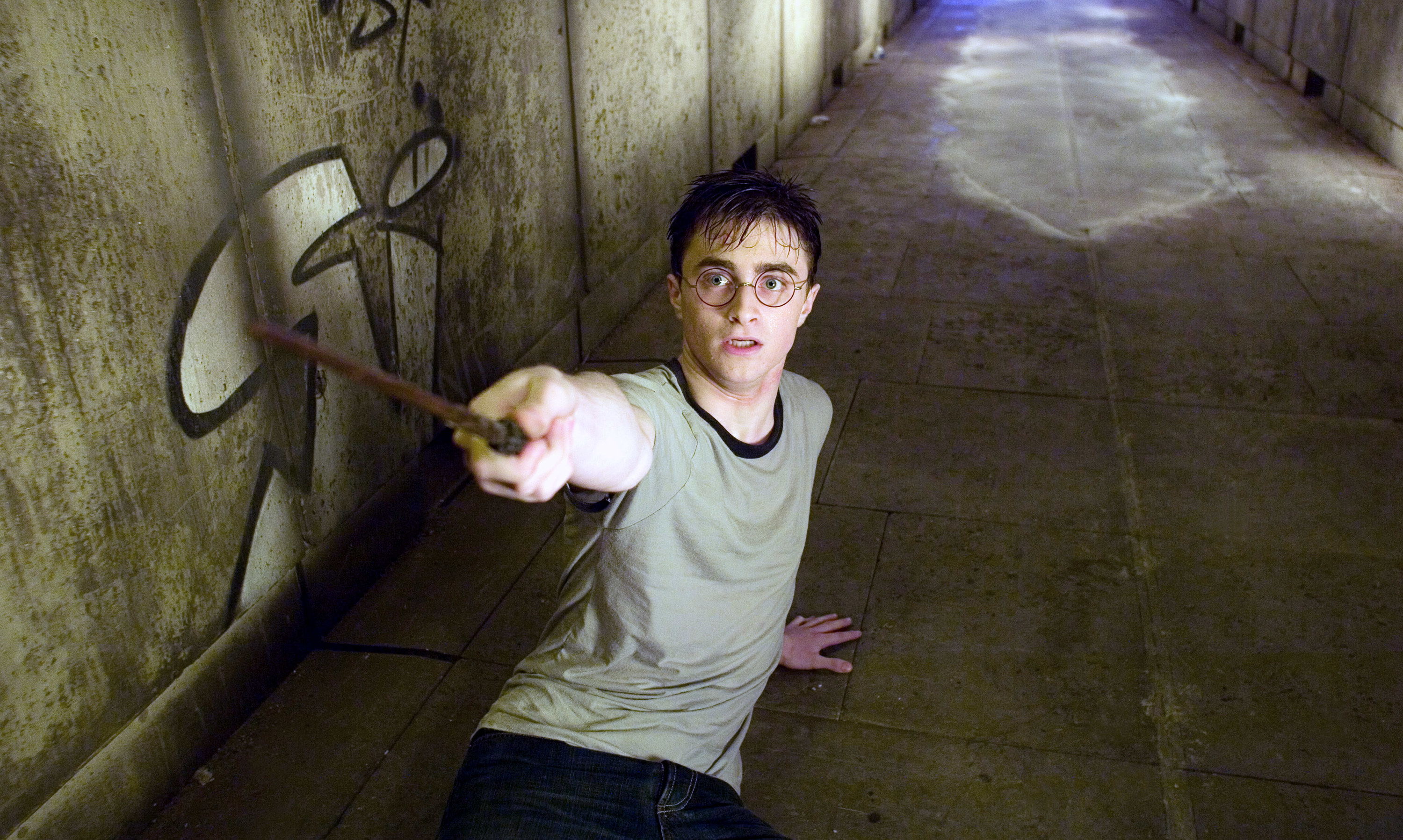 Radcliffe points a wand while on the ground