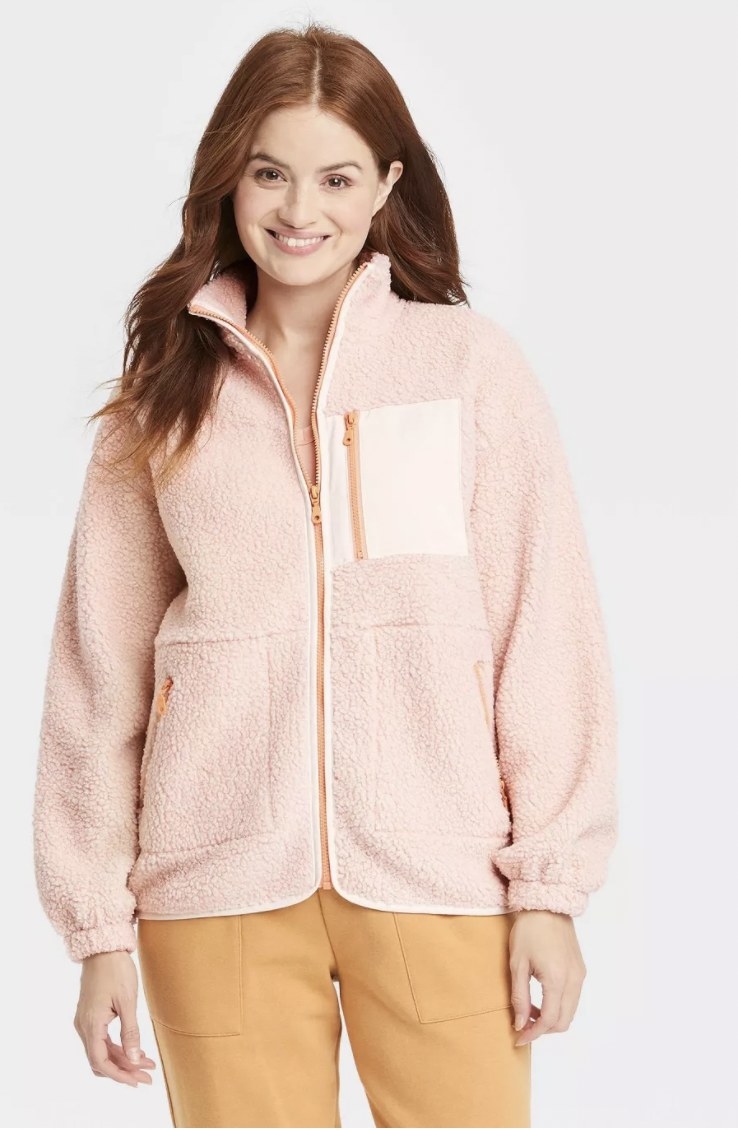 model wearing pink sherpa jacket and orange pants