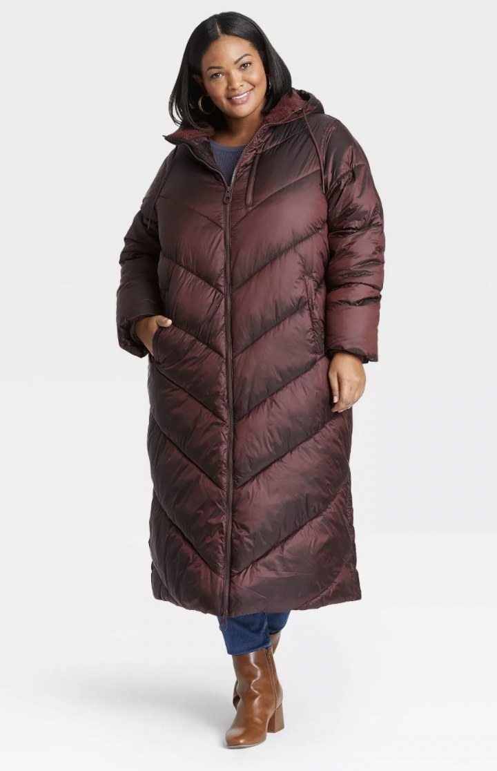 model wearing long burgundy puffer jacket with brown booties