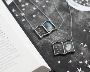 Two book necklaces with printed feathers and stars in them