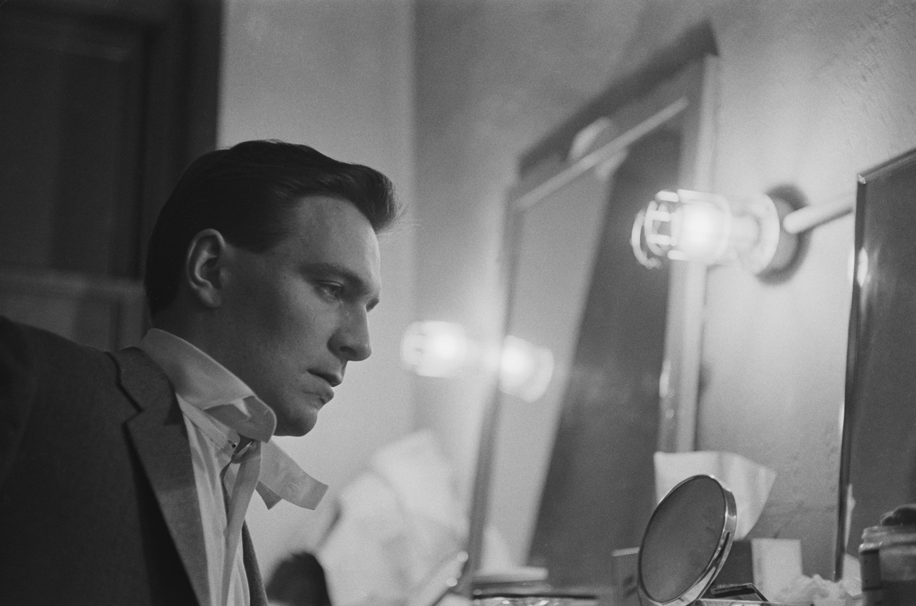 Christopher Plummer in a tuxedo looking past a mirror backstage at a broadway show