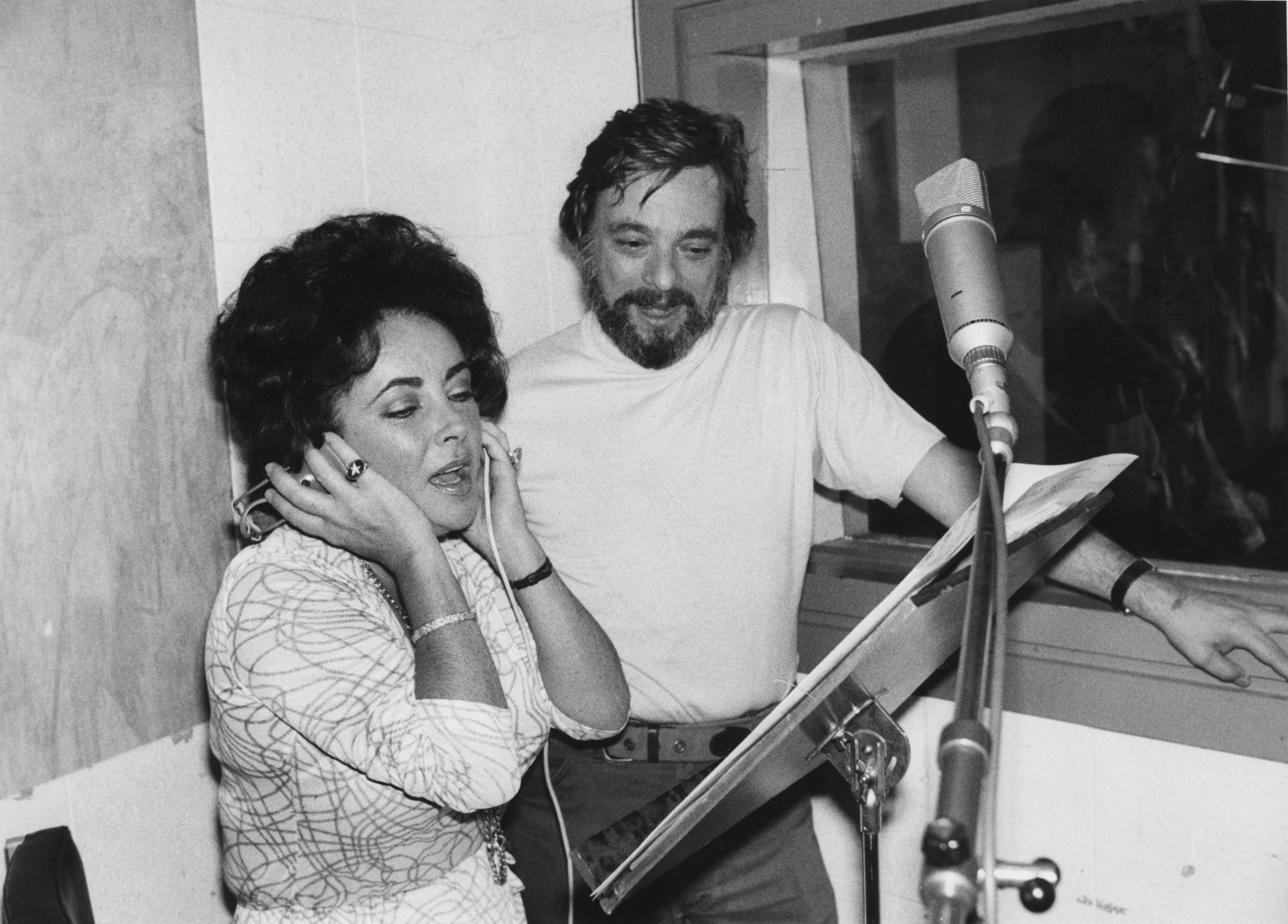 Elizabeth Taylor singing while looking at music with Stephen Sondheim next to her