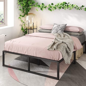 Image of the bed frame with pink and gray sheets
