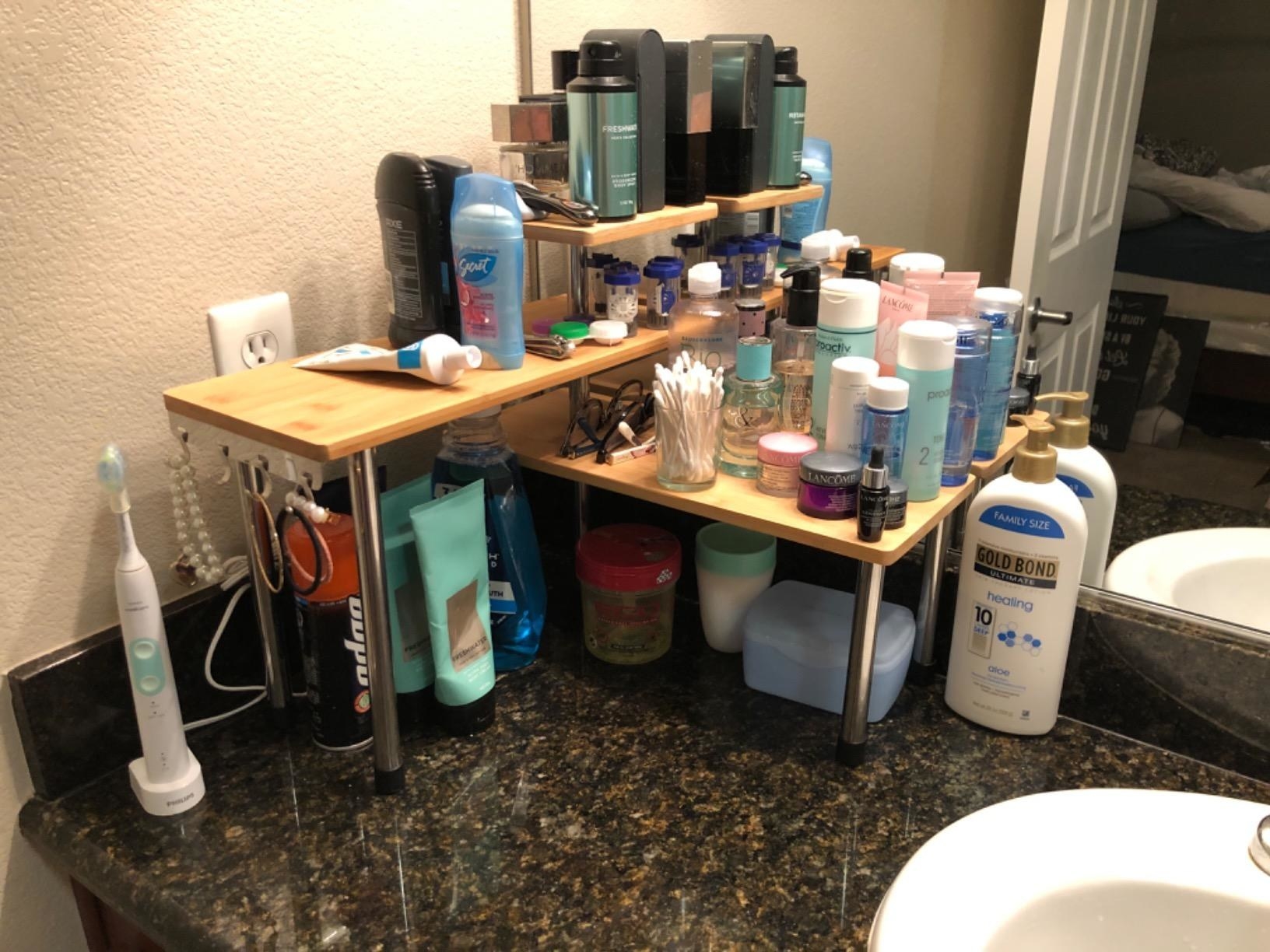 A three-tier rack in the corner of a bathroom counter