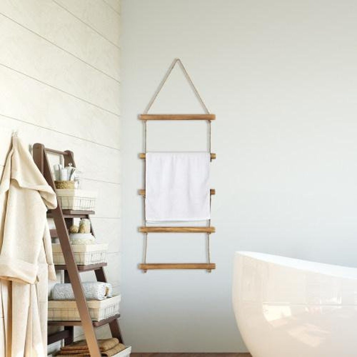 a hanging ladder made of wood and rope holding a towel in a bathroom