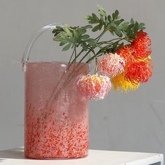the medium pink vase holding pink, yellow, and orange flowers