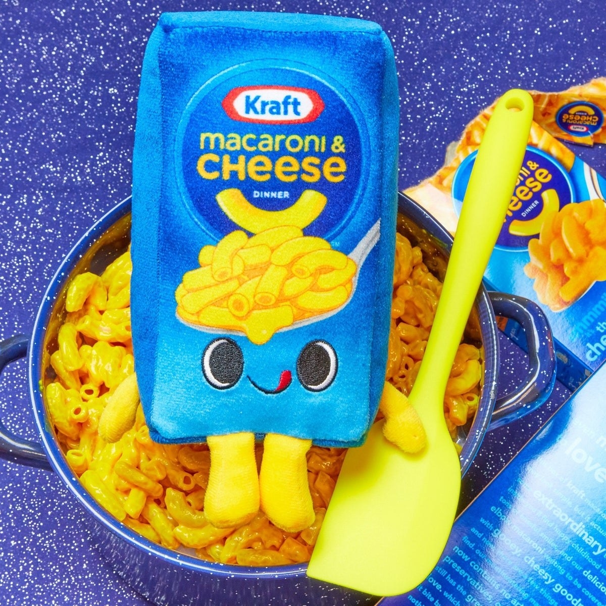 plush mac n cheese box with arms legs and cute face licking its lips