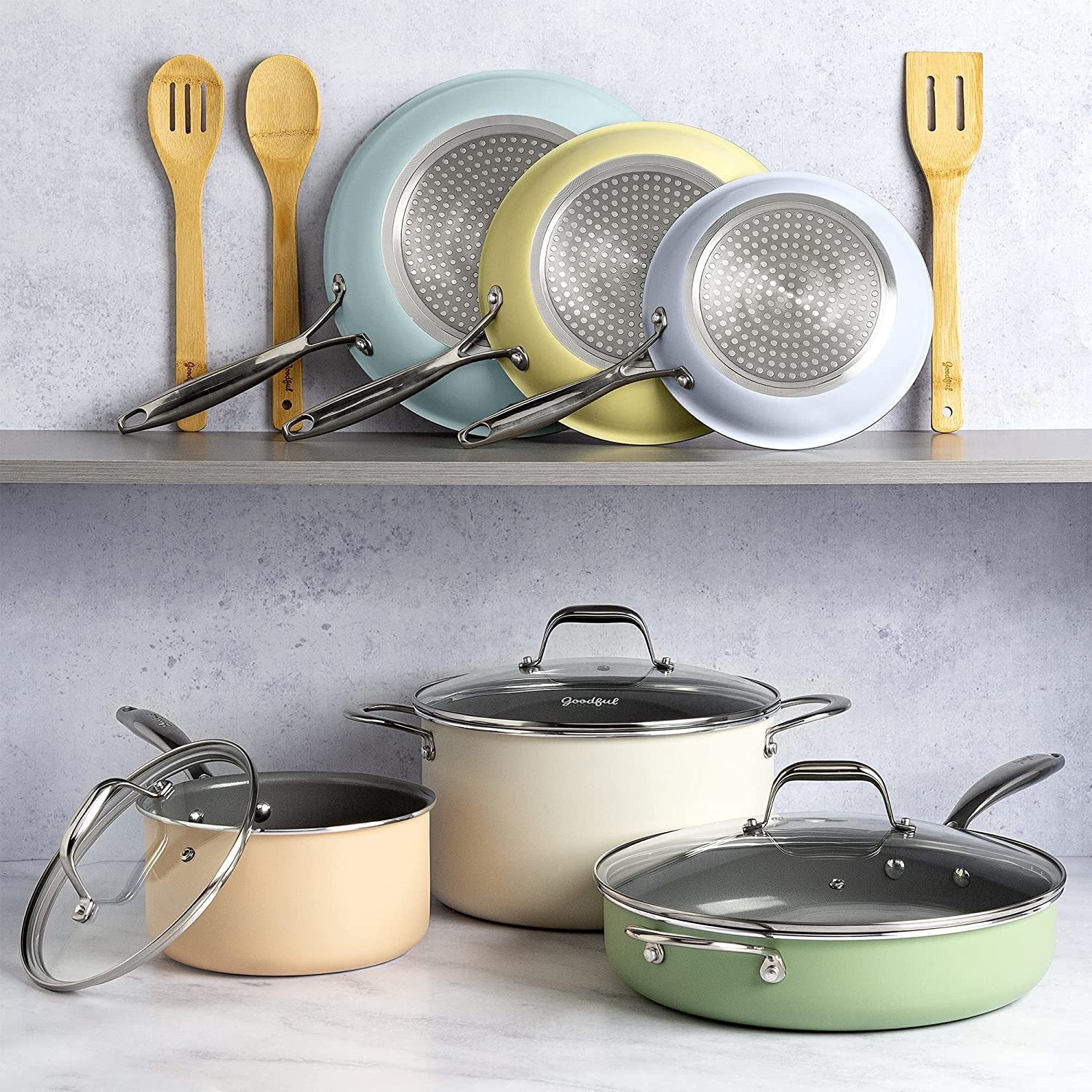 Multicolored pots, pans, and bamboo spatulas lined up on kitchen shelf and countertop