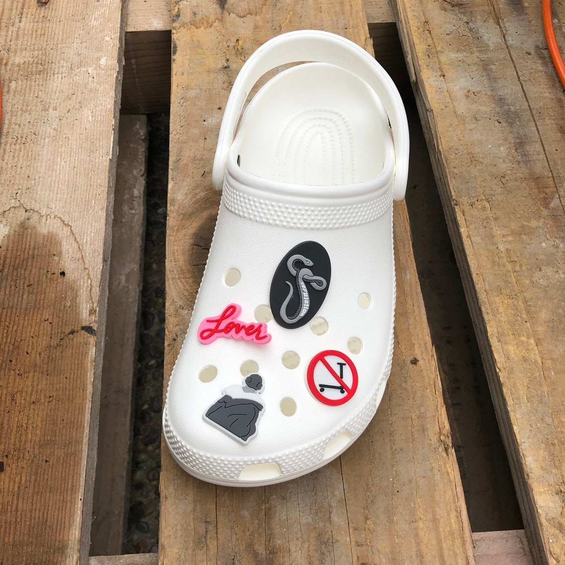 white croc with charms referencing folklore, lover, reputation, and the &quot;no scooter&quot; sign from the &quot;the man&quot; video