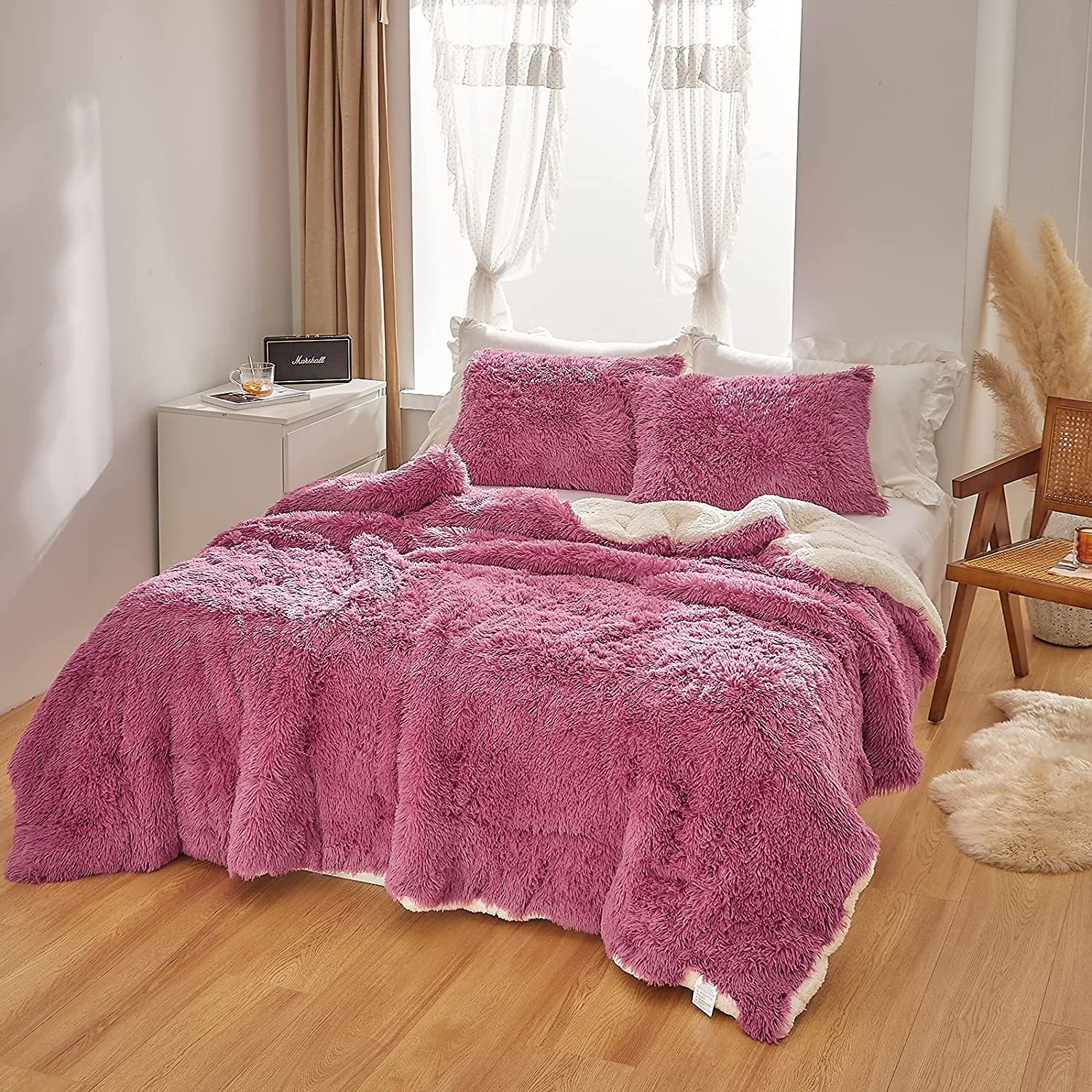 raspberry-colored faux fur comforter and pillowcases on bed