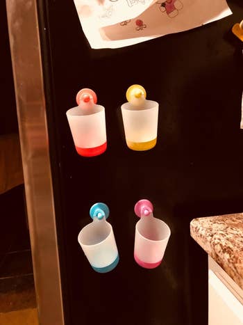 Reviewer's photo of four colorful cups hanging on their fridge