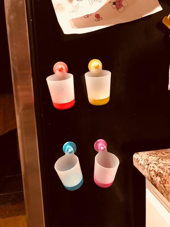 Four colorful cups hanging on a reviewers fridge