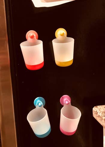 Reviewer's photo of four colorful cups hanging on their fridge