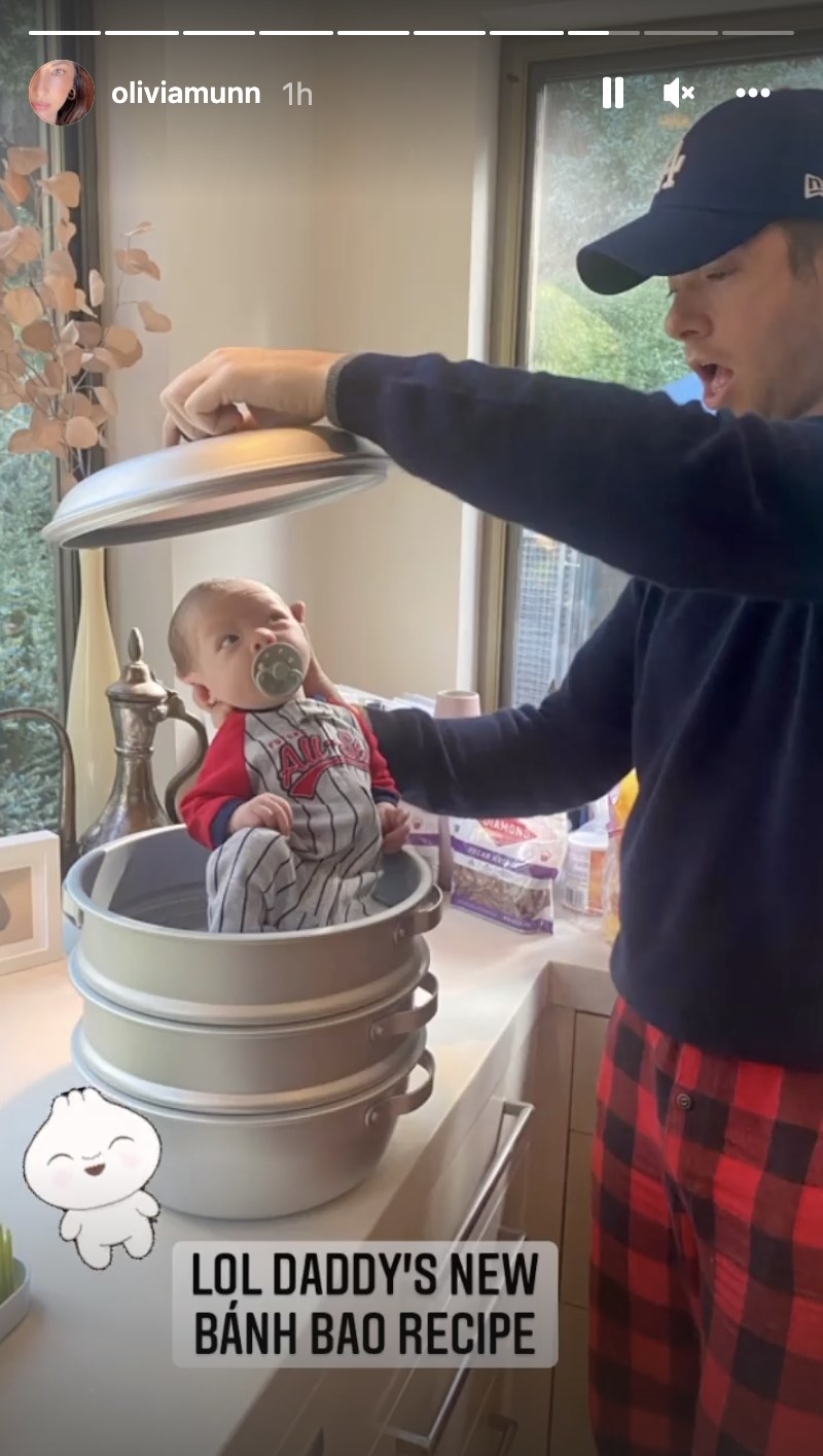 John holds a baby on top of a metal pot and hold the top above the baby&#x27;s head