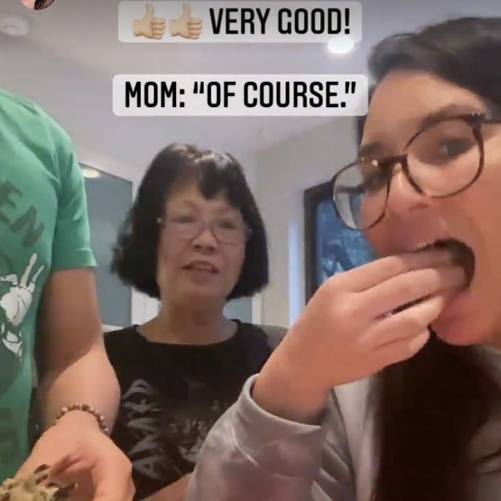 Olivia puts a piece of food into her mouth while her mom looks on