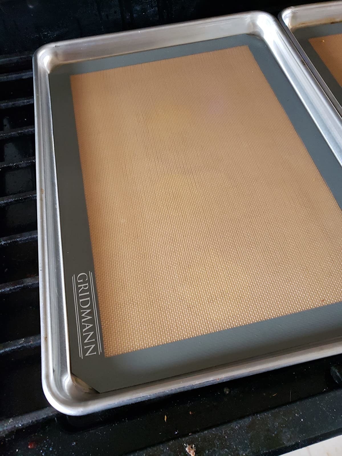 Reviewer image of gray and cream silicone baking mat on sliver baking tray