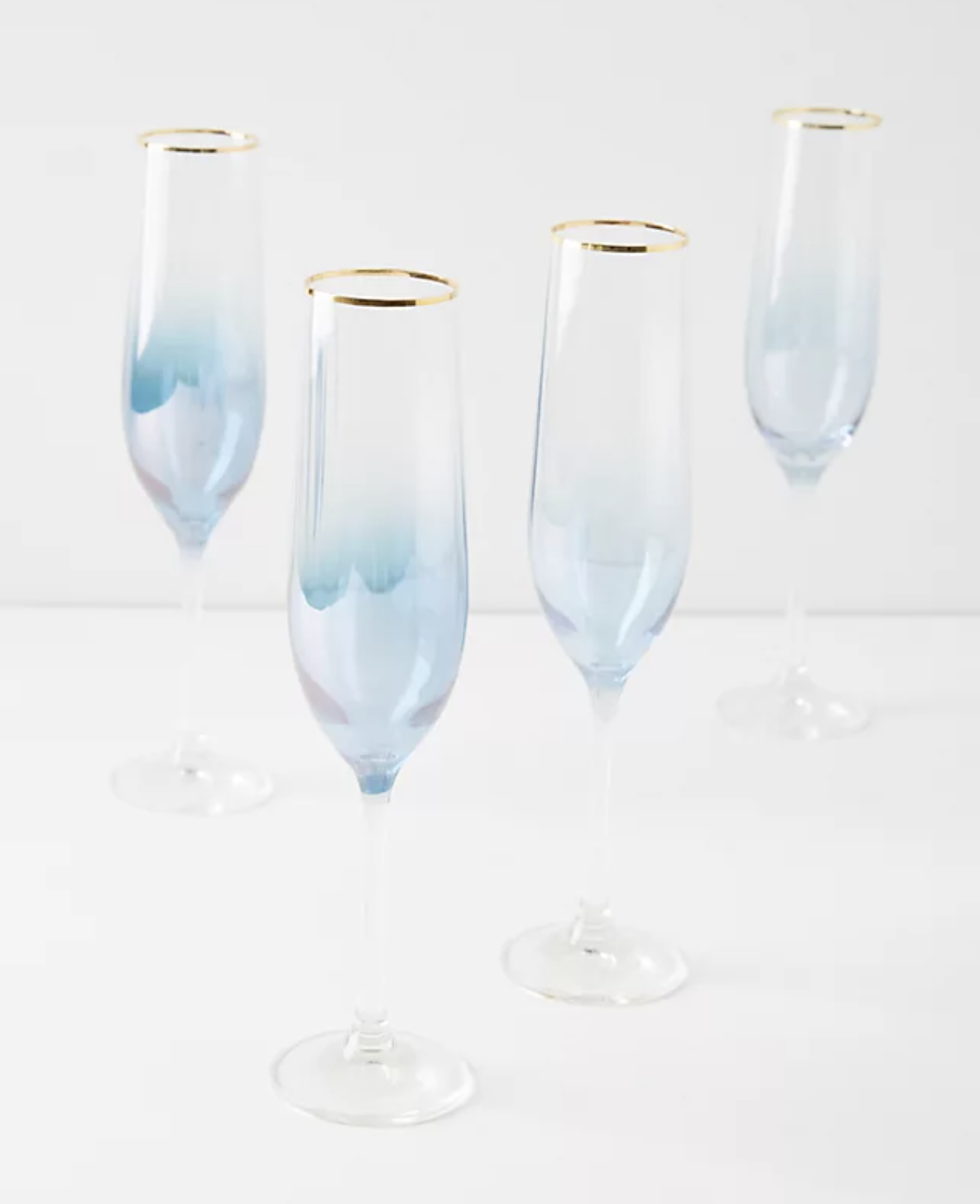 Set of four light blue and clear champagne glasses with gold accents