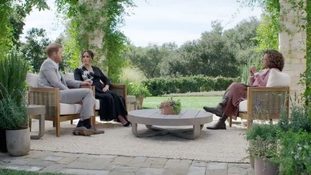 Harry Windsor, Meghan Markle and oprah winfrey sat in a large green garden