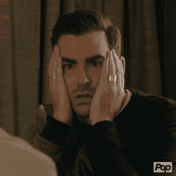 Dan Levy as David Rose presses his hands to either side of his face before pulling them away and lowering his eyebrows in &quot;Schitt&#x27;s Creek&quot;