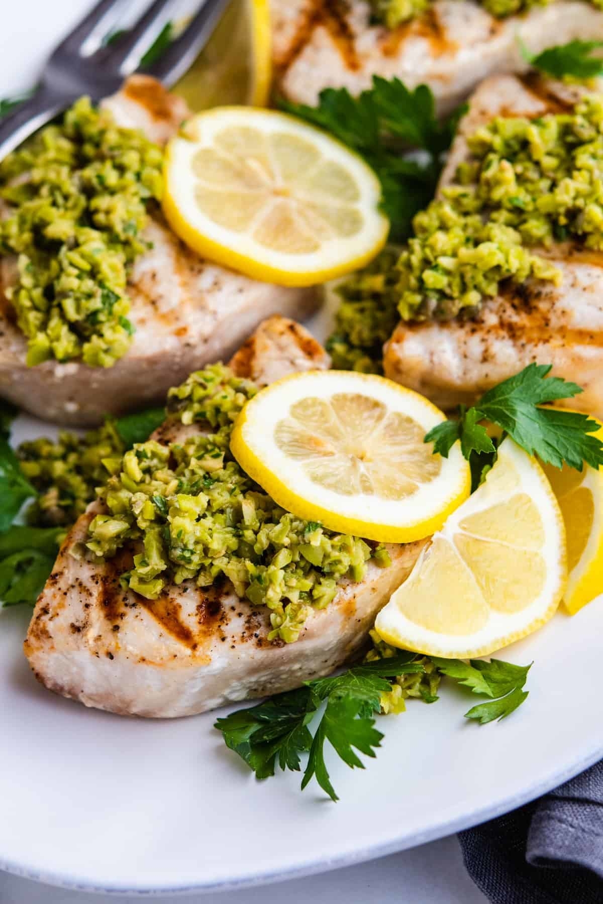 Tender, buttery grilled swordfish topped with a bright and briny green olive tapenade.