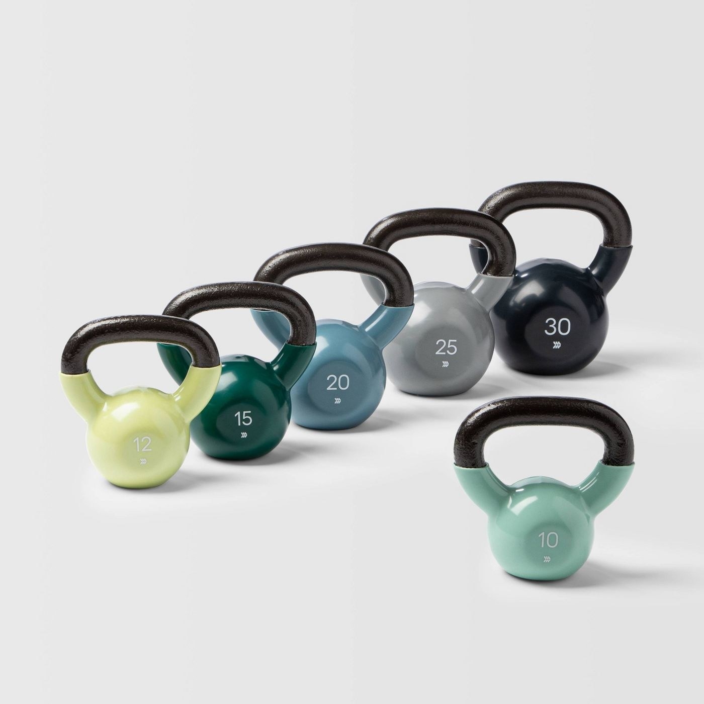 A set of different colored kettlebells between weights 10 to 30 pounds.
