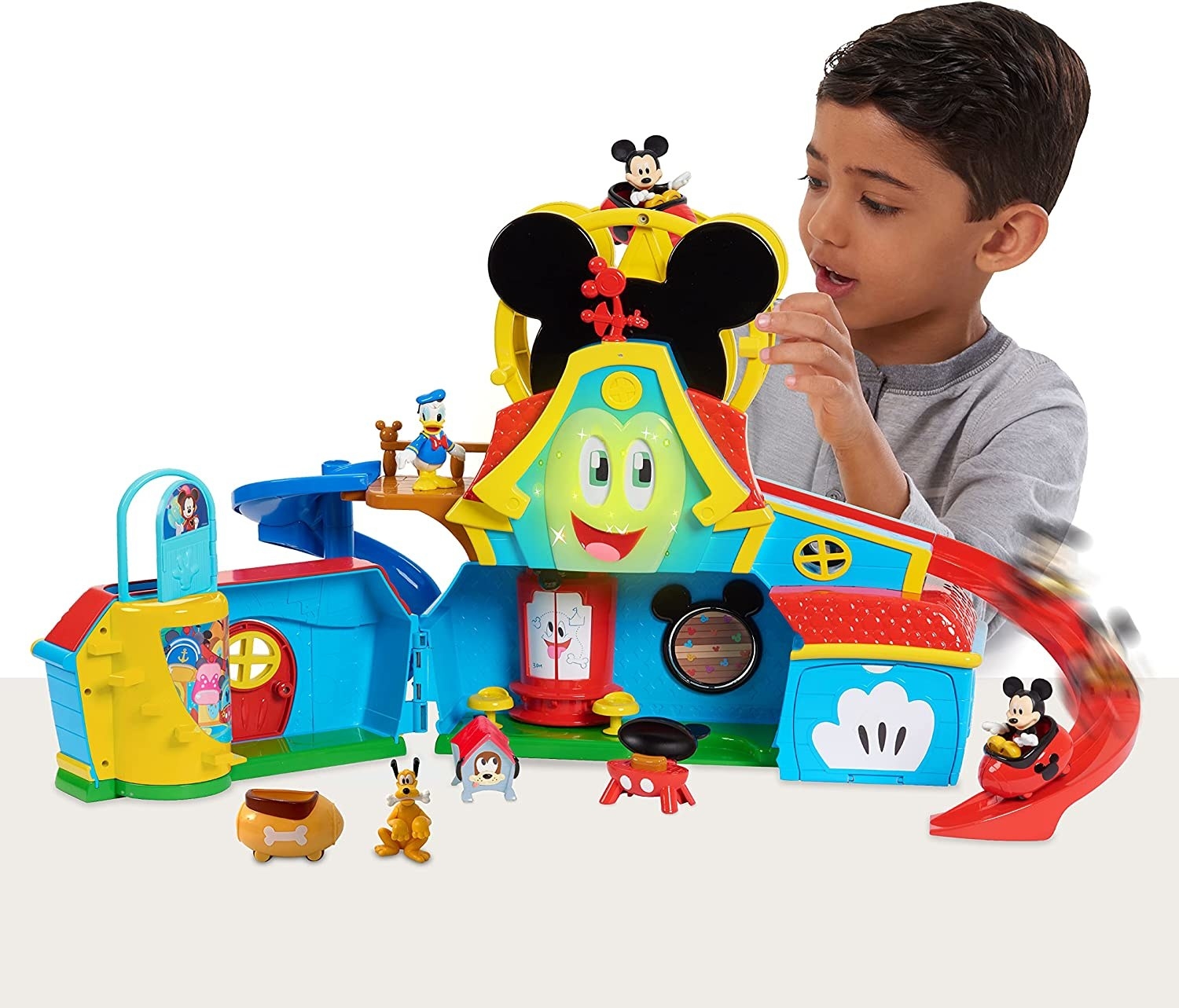 a child playing with the funhouse while a mickey mouse character goes down a slide