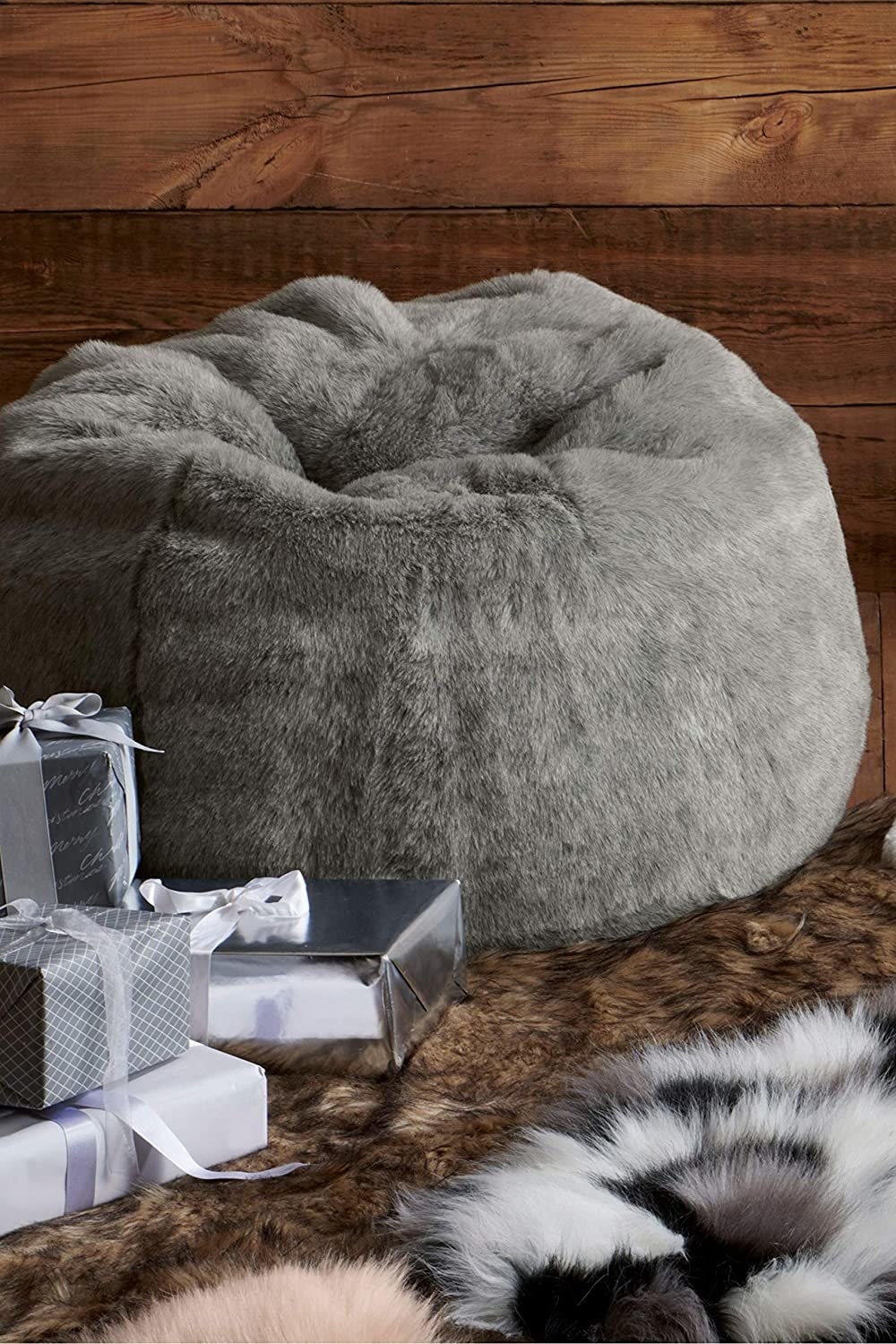 A grey fluffy bean bag chair on a soft rug