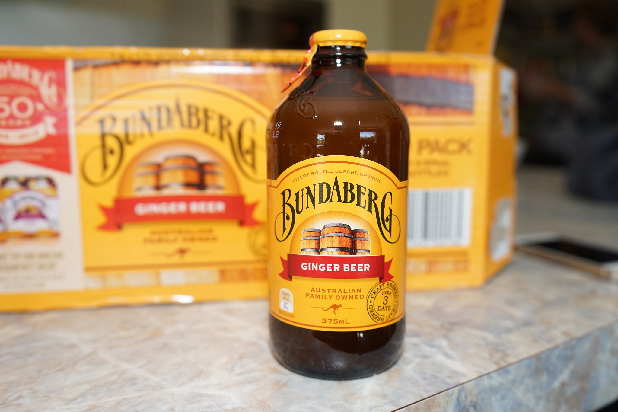 A bottle of Bundaberg ginger beer, with a case of it in the background