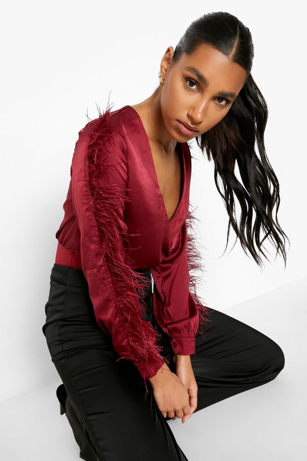 Model wearing burgundy blouse with deep neckline