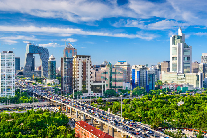 A highway in Beijing filled with traffic and the skyscrapers in the background