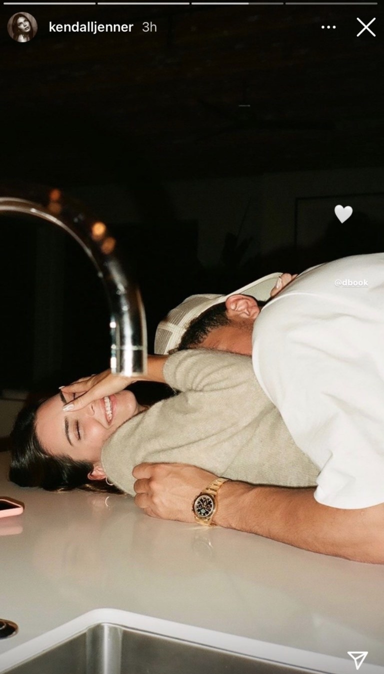 Kendall Jenner lies on her back on her kitchen countertop while Devin Booker rests on top her
