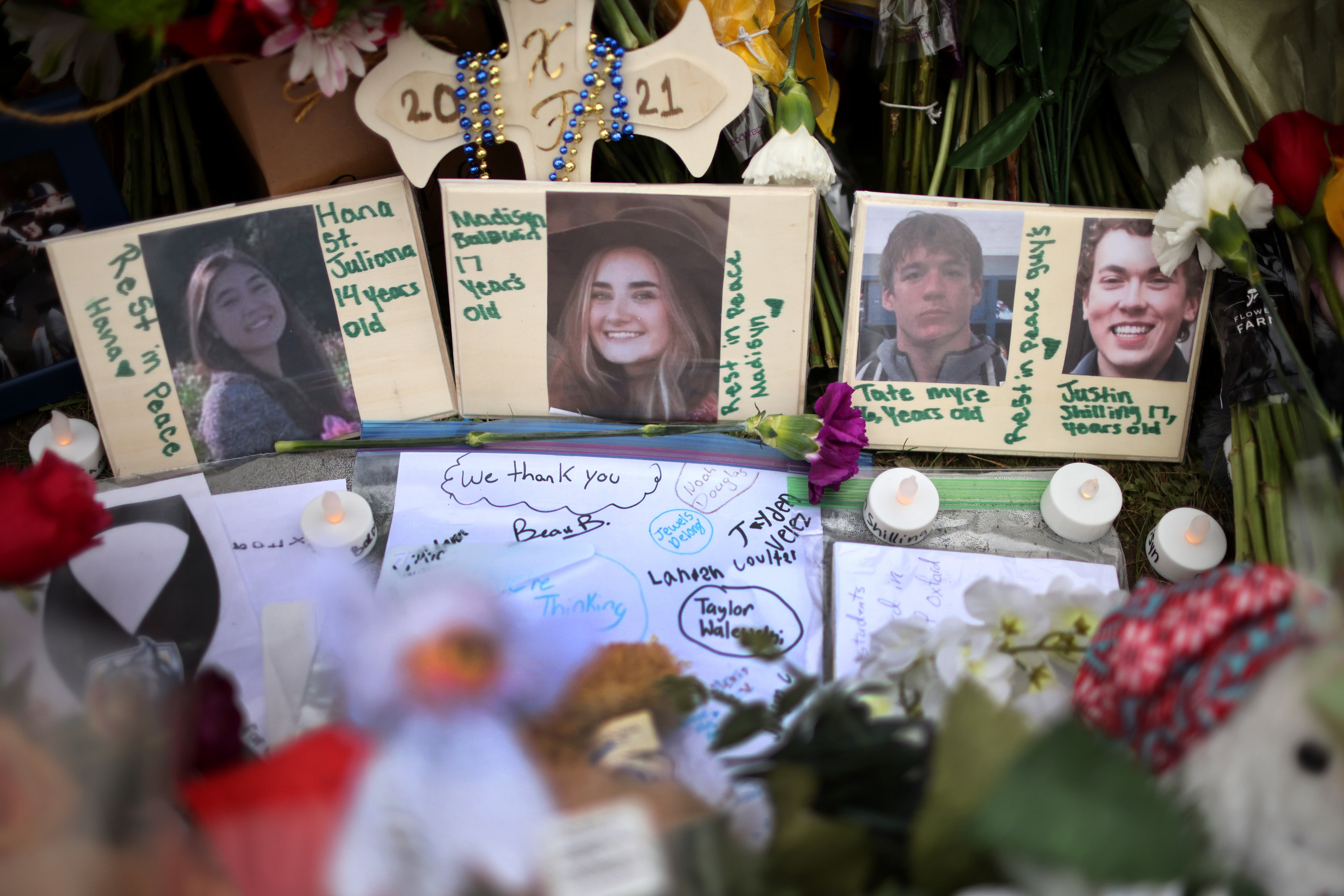 Memorial showing photos of the four students killed in the shooting alongside handwritten notes and lights
