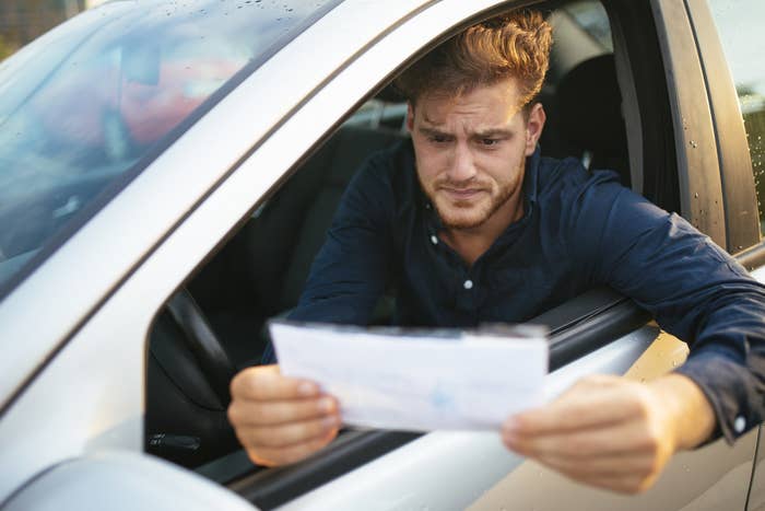 Man in the driver&#x27;s seat looking at a piece of paper