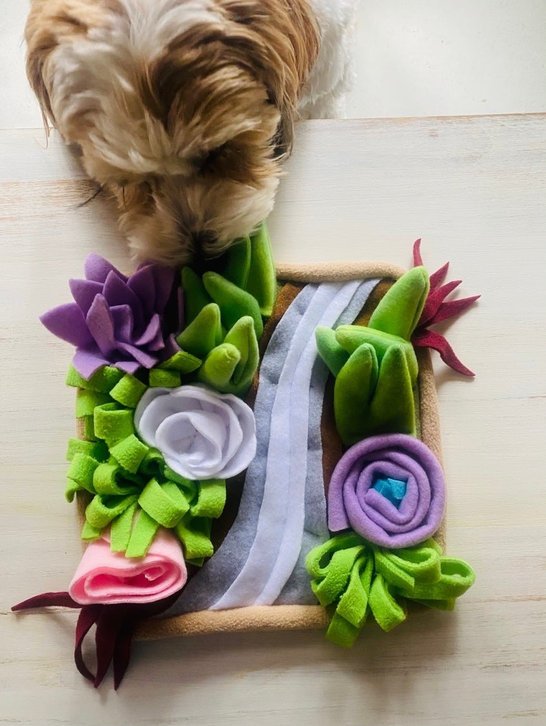 dog sniffing a snuffle mat that looks like a garden