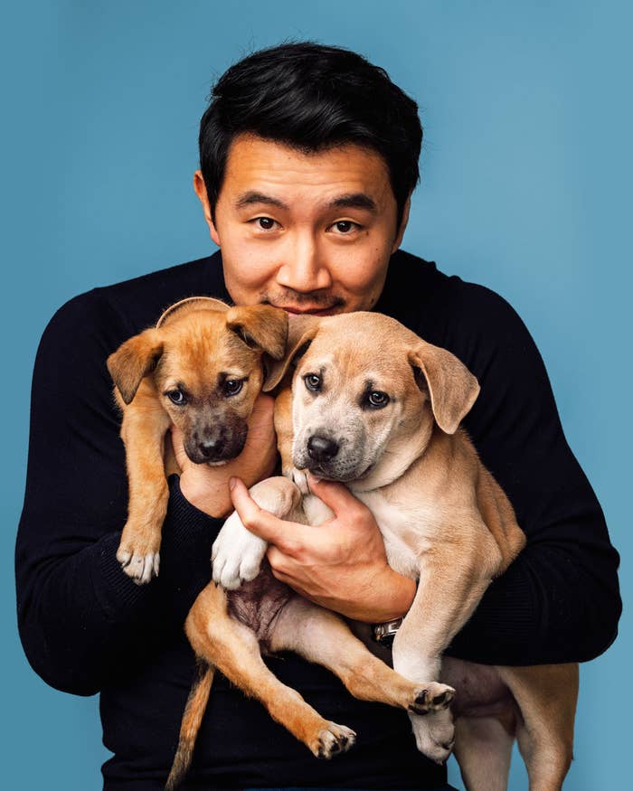 Simu holding two dogs in his arms