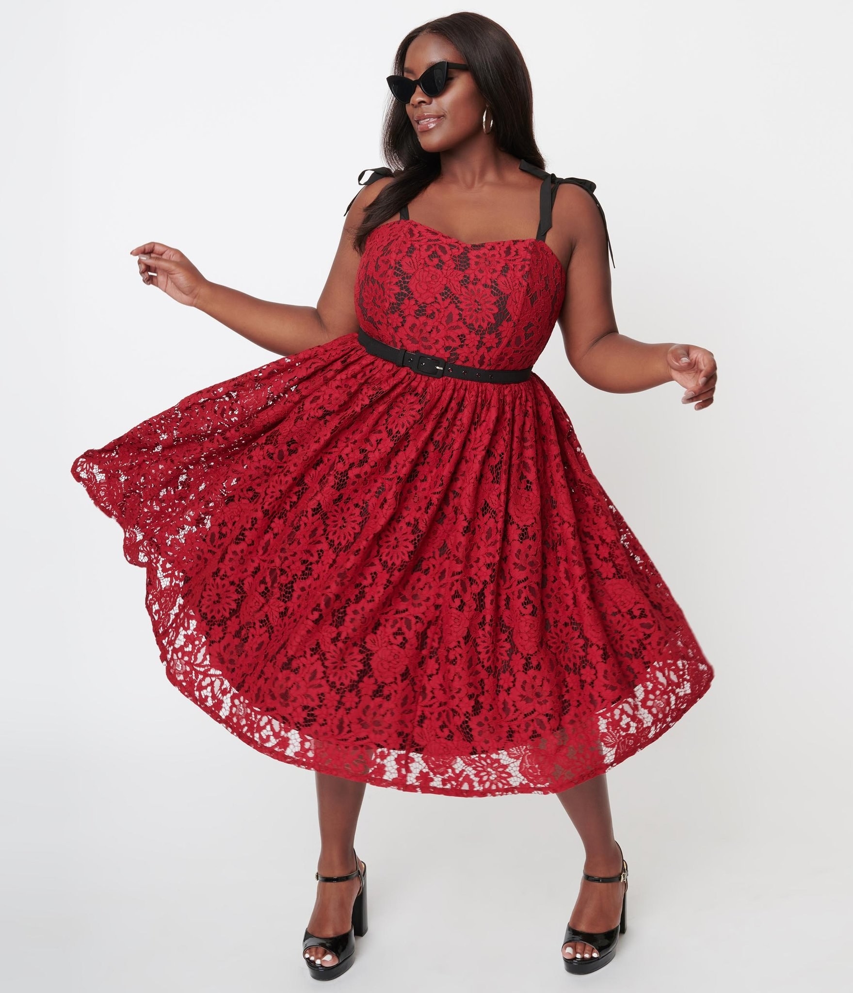 model in red lace dress with black underlay, straps, and belt